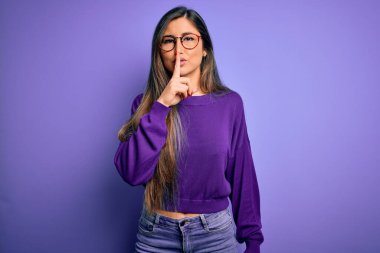 Mor izole edilmiş arka planda gözlük takan güzel ve zeki bir kadın sessiz olmak istiyor. Sessizlik ve gizli konsept.