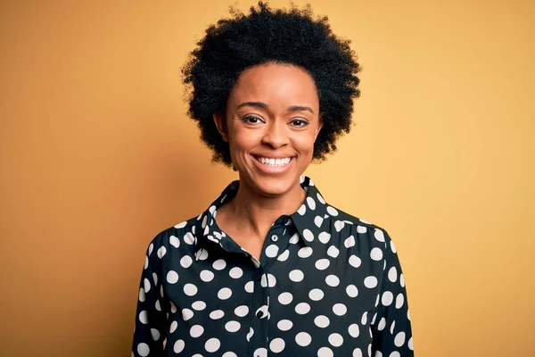顔に幸せとクールな笑顔で立ってカジュアルなシャツを着て巻き毛を持つ若い美しいアフリカ系アメリカ人アフロ女性 運のいい人 — ストック写真