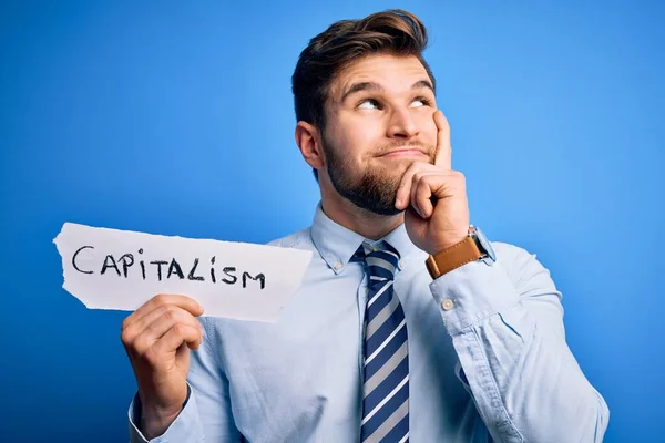 Young Blond Businessman Beard Blue Eyes Holding Paper Capitalism Message — Stock Photo, Image