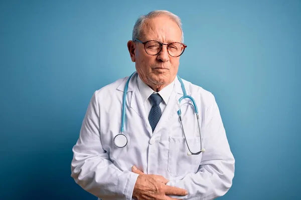 Senior Grijze Harige Arts Draagt Stethoscoop Medische Jas Blauwe Achtergrond — Stockfoto