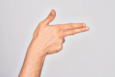 Beyaz arka planda parmaklarını gösteren beyaz tenli bir adamın eli. Ateşli silahı parmaklarıyla işaret ediyor.