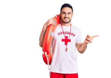 Cankurtaran üniforması giyen yakışıklı genç adam elinde şamandıra, gülümsüyor mutlu bir şekilde elini ve parmağını yana doğru uzatıyordu. 