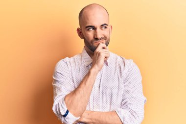 Zarif bir gömlek giyen genç ve kel bir adam şüpheye odaklanmıştı. Parmakları çenesinde ve yukarı bakıyordu. 