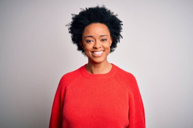 Kıvırcık saçlı, kırmızı bir kazak giyen, yüzünde mutlu ve havalı bir gülümseme olan güzel Afro-Amerikan bir kadın. Şanslı kişi..