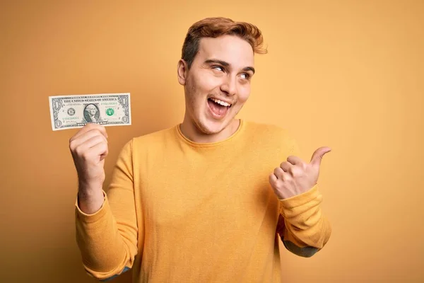 Joven Pelirrojo Guapo Sosteniendo Billetes Dólar Sobre Fondo Amarillo Aislado —  Fotos de Stock