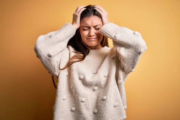 年轻美丽的女人 蓝眼睛 身穿休闲衫 站在黄色的背景上 因疼痛和偏头痛而感到绝望和压力 手放在头上 — 图库照片