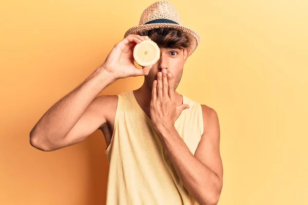 若いヒスパニック系の男は手で口をカバーレモンを保持し ショックを受け 間違いを恐れている 驚きの表情 — ストック写真