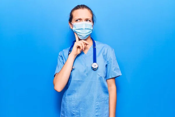 Doktor Üniforması Giyen Tıbbi Maske Takan Genç Sarışın Kadın Şüpheye — Stok fotoğraf