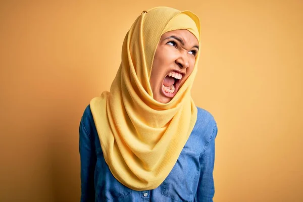 年轻美丽的女人 头戴阿拉伯式传统头巾 头戴黄色背景 怒气冲冲地狂叫 怒气冲冲地大叫 愤怒和好斗的概念 — 图库照片