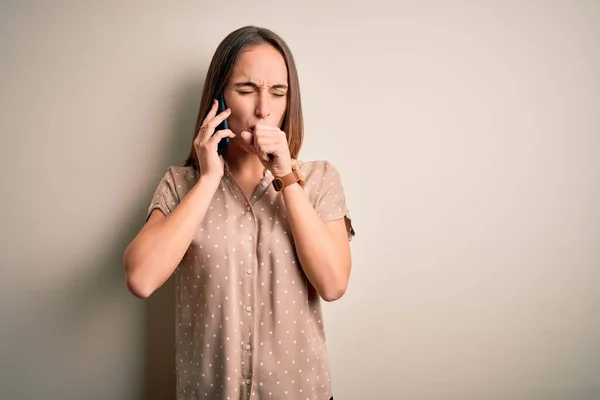 年轻美丽的女人在智能手机上通过白色背景聊天时感觉身体不适 咳嗽是感冒或支气管炎的症状 保健概念 — 图库照片