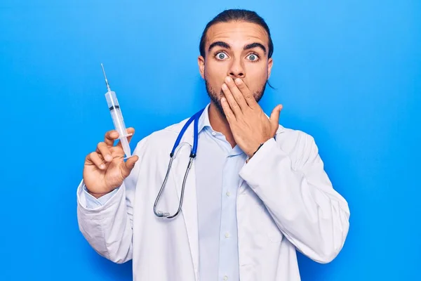 Jovem Bonito Homem Usando Médico Estetoscópio Segurando Seringa Cobrindo Boca — Fotografia de Stock