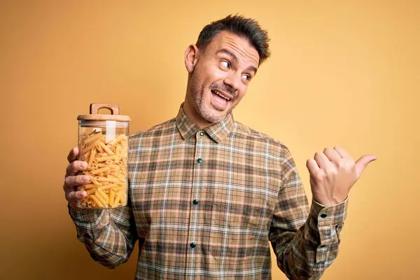 Ung Stilig Man Håller Burk Med Torr Italiensk Pasta Makaroner — Stockfoto
