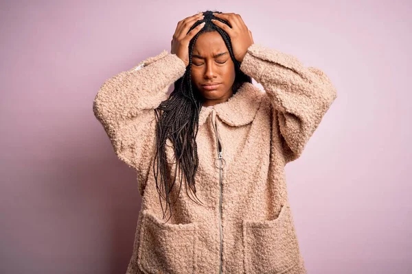 年轻的非洲裔美国女人穿着时尚的冬季外套 背景是粉红色的 孤立的 因疼痛和偏头痛而感到绝望和压力 手放在头上 — 图库照片