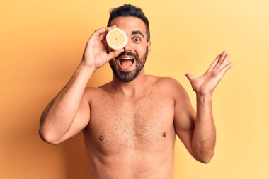 İspanyol asıllı genç adam limonsuz bir şekilde elinde limonla başarıyı mutlu bir gülümsemeyle kutluyor ve kazanan el kaldırarak ifade ediyor. 