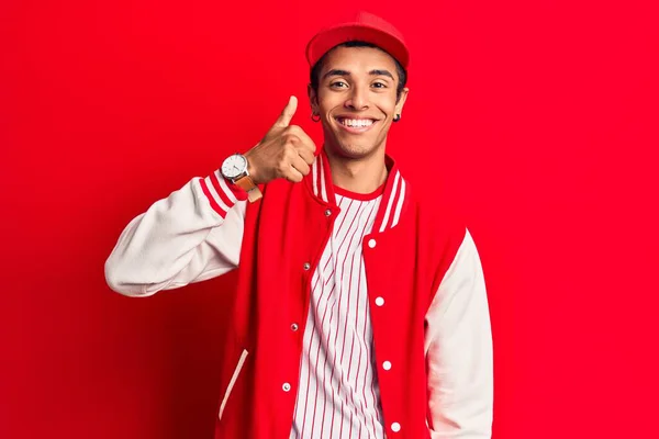 野球の制服を着た若いアフリカ系アメリカ人の男が笑顔と肯定的な 親指アップ優れた承認サインを行う — ストック写真