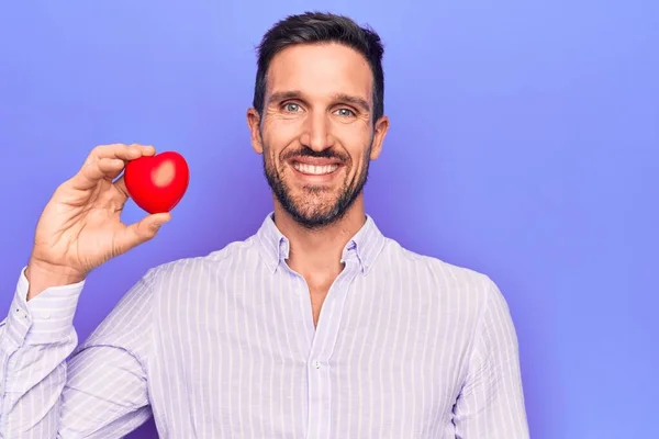 Young Handsome Man Asking Health Care Holding Red Heart Isolated — Stock Photo, Image