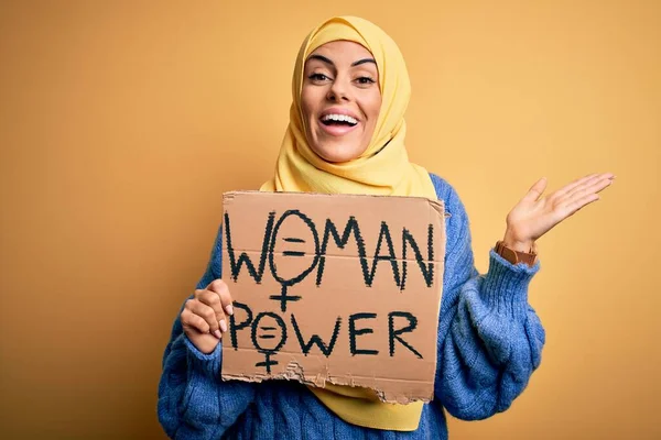 女性のパワーメッセージとのバナーを保持するイスラムヒジャーブを身に着けている若い美しいアラブ女性は非常に幸せと興奮 大きな笑顔で叫んで勝利を祝う勝者式と手を上げ — ストック写真