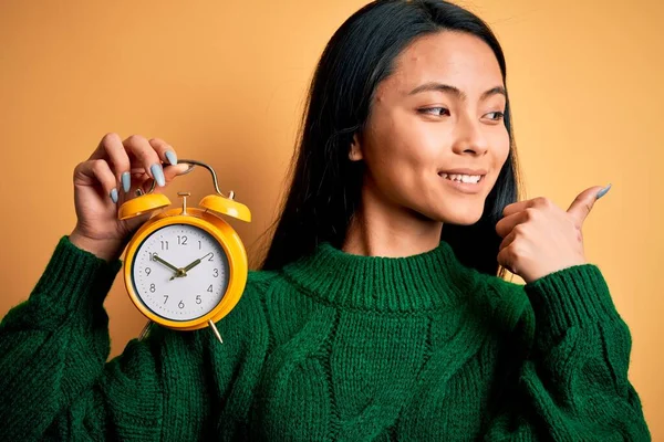 Junge Schöne Chinesin Hält Vintage Wecker Über Isolierten Gelben Hintergrund — Stockfoto