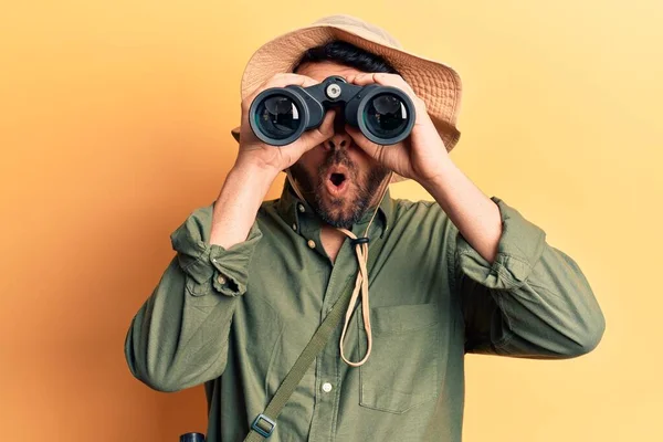 Junger Hispanischer Mann Mit Forscherhut Fernglas Der Hand Erschrocken Und — Stockfoto