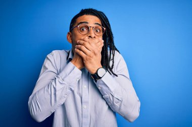 Rastgele gömlek ve gözlük takan Afro-Amerikan genç yakışıklı adam yanlışlıkla elleri ile ağzını kapatırken şok oldu. Gizli konsept.