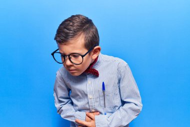 Sevimli sarışın çocuk inek papyonu takıyor ve eli karnında gözlük takıyor çünkü hazımsızlık, acı verici bir hastalık kendini iyi hissetmiyor. Ağrı kavramı. 