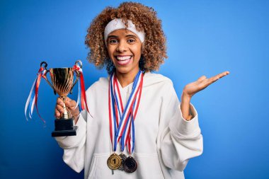 Genç Afrikalı Amerikalı sporcu kadın spor yapıyor. Madalya ve kupa kazanıyor. Çok mutlu ve heyecanlı.