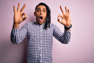 Rastgele gömlek giyen Afrikalı Afro-Amerikan genç adam şaşırmış ve şaşırmış görünüyor. Çılgın ifade