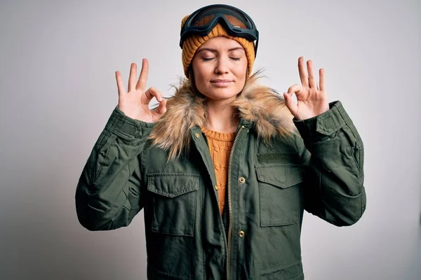 年轻美丽的滑雪者女人 蓝眼睛 身穿雪地运动服和滑雪护目镜 闭上双眼微笑 用手指做冥想动作 瑜伽概念 — 图库照片