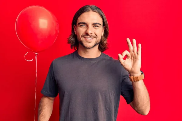 Ung Stilig Man Håller Ballong Gör Tecken Med Fingrar Ler — Stockfoto