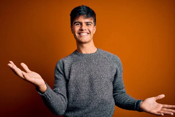 Jovem Homem Bonito Vestindo Camisola Casual Sobre Fundo Laranja Isolado — Fotografia de Stock