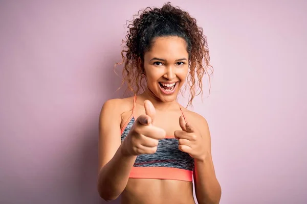 漂亮的女运动员 身穿运动服 穿着粉色背景的运动服 手指指向镜头 脸上带着快乐和滑稽的表情 好的能量和活力 — 图库照片