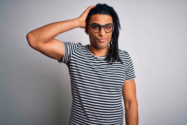 Rasta giyen, çizgili tişört giyen ve gözlük takan Afro-Amerikan genç yakışıklı adam soru sorup şaşırıyor. Şüpheyle kararsız, kafa kafaya düşünerek. Düşünceli kavram.