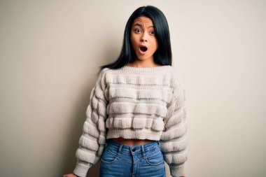 Genç, güzel Çinli kadın, izole edilmiş beyaz arka plan üzerine gündelik süveter giyiyor. Şaşırtıcı bir ifade, korku ve heyecan dolu bir yüz ifadesi var..