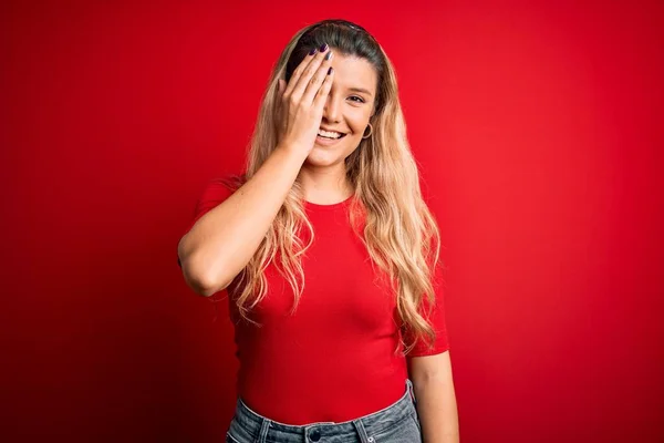 Jovem Mulher Loira Bonita Vestindo Camiseta Casual Sobre Fundo Vermelho — Fotografia de Stock