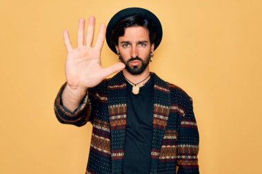 Genç, yakışıklı, bohem, hippi tarzı giyinmiş ve bohem şapkalı bir adam avucunun içi gibi şarkı söylemeyi kesiyor. Yüzünde olumsuz ve ciddi bir jest olan uyarı ifadesi.