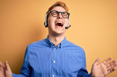 Gözlüklü, genç, kızıl saçlı çağrı merkezi temsilcisi. Başarı kutlamaları için kulaklık takıyor. Kolları havada, gözleri kapalı, heyecanlı bir şekilde bağırıyor. Kazanan konsept