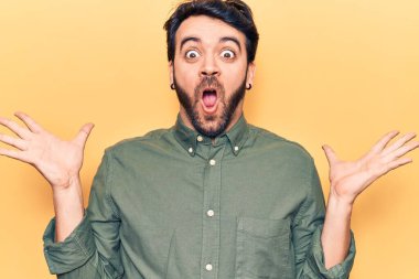 Gündelik kıyafetler giyen genç İspanyol adam zaferi mutlu bir gülümsemeyle ve kazanan yüz ifadesiyle kutluyor. 