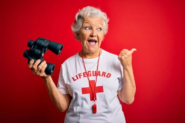 Senior Schöne Grauhaarige Rettungsschwimmerin Mit Fernglas Und Pfeife Über Roten — Stockfoto