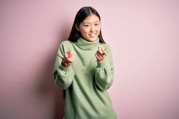 Jonge Mooie Aziatische Vrouw Draagt Groene Wintertrui Roze Gesoldeerde Achtergrond — Stockfoto