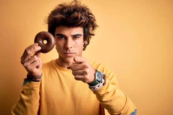 Mladý Pohledný Muž Drží Čokoládové Koblihy Stojící Nad Izolovaným Žlutým — Stock fotografie