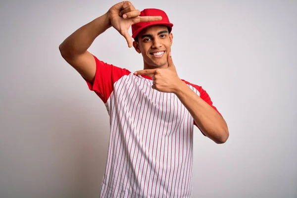 縞模様の野球Tシャツを着た若いハンサムなアフリカ系アメリカ人スポーツマンと幸せな顔をした手と指でフレームを作り笑顔キャップ 創造性と写真の概念 — ストック写真