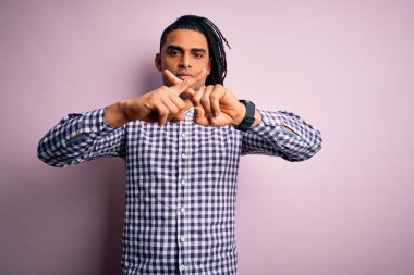 Rastgele gömlek giyen Afro-Amerikan genç, yakışıklı Afro-adam. Reddedilme ifadesi olumsuz işaret veriyor.