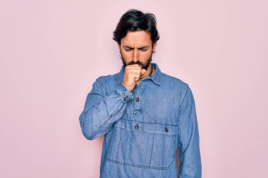 Pembe arka planda hippi tarzı giyinen yakışıklı İspanyol bohem adam kendini iyi hissetmiyor ve soğuk algınlığı veya bronşitin belirtisi olarak öksürüyor. Sağlık hizmeti kavramı.