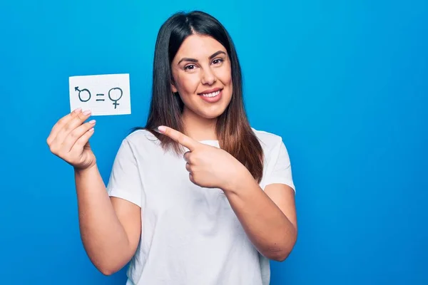 Beautiful woman asking for sex discrimination holding paper with gender equality concept smiling happy pointing with hand and finger