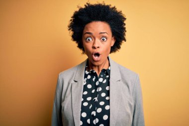 Kıvırcık saçlı, ceketli, korkmuş ve şok olmuş genç Afro-Amerikan iş kadını..