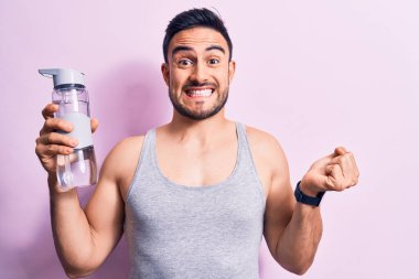 Sakallı genç yakışıklı sporcu kolsuz tişört giyiyor. Bir şişe su içiyor. Gururla bağırıyor, zaferi kutluyor.