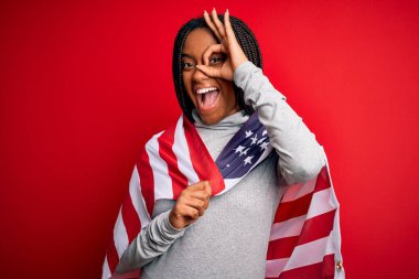 Bağımsızlık gününde Amerika Birleşik Devletleri bayrağı taşıyan, mutlu yüzlü, el pençe divan duran genç, Afro-Amerikan vatansever kadın.