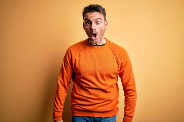 Jovem Homem Bonito Vestindo Camisola Casual Laranja Sobre Fundo Amarelo — Fotografia de Stock