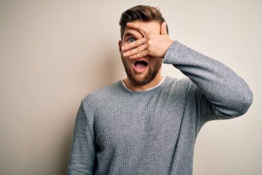 Sakallı, mavi gözlü, genç, yakışıklı bir adam. Sıradan bir süveter giyiyor. Şok geçiriyor, yüzünü ve gözlerini eliyle kapatıyor..