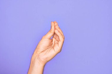 İzole edilmiş mor arka planda parmaklarını gösteren beyaz bir gencin eli parmaklarıyla İtalyanca jest yapıyor, iletişim hareketi yapıyor.